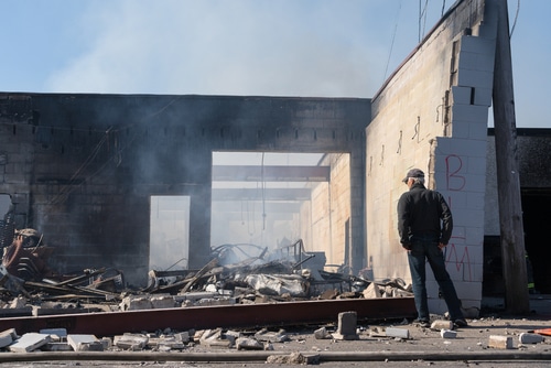 Man looking at fire damage to his building after a building fire