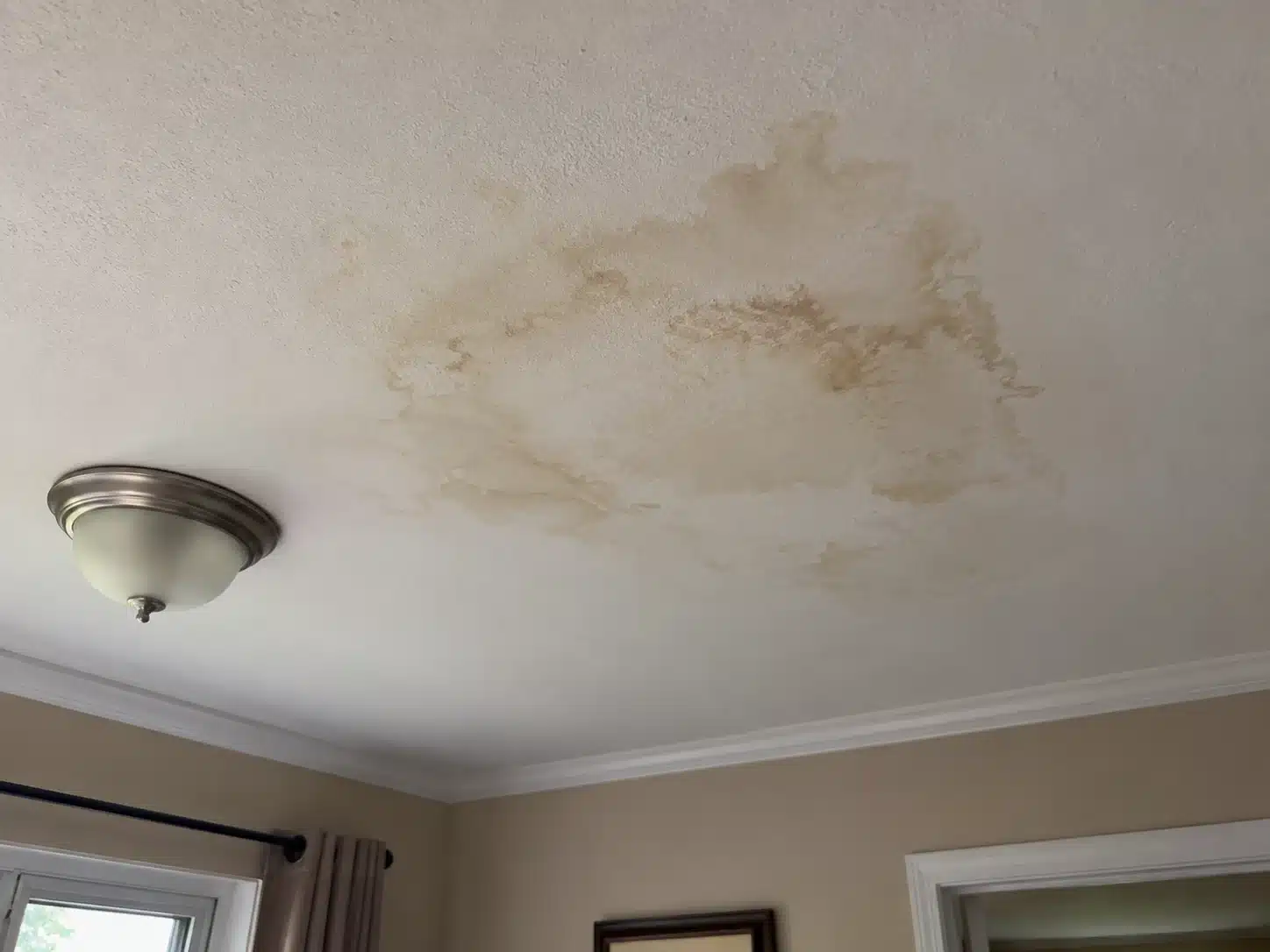 Water-damaged ceiling drywall showing staining and deterioration